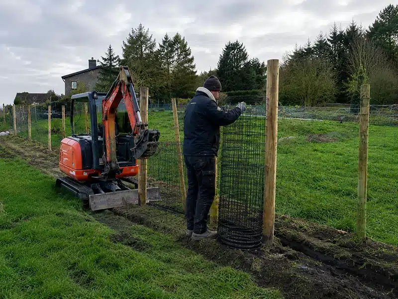 Paysagiste posant une clôture sur un chantier extérieur à Namur